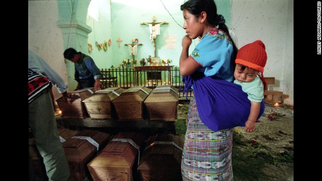 At a Guatemalan church in Rabinal in 2002, a grieving mother stands over the remains of her daughter, a victim of a massacre allegedly conducted by the army in 1982. Coffins bearing victims' remains were brought to the church months after archeologists found and exhumed the bodies based on witness testimony. 