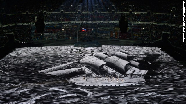 People move as a boat is projected across the floor of the stadium.