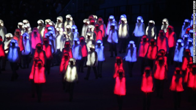 Performers in illuminated red, white and blue outfits prepare to form the Russian national flag.