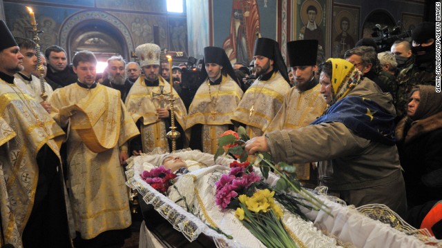 Orthodox priests lead the funeral service for slain protester Mikhail Zhiznevsky in Kiev on Sunday, January 26.