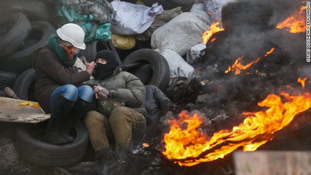 A couple try to keep warm near a fire at a barricade in Kiev on January 27.