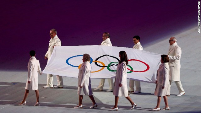 Olympic flag bearers carry the flag onto the floor during the opening ceremony.
