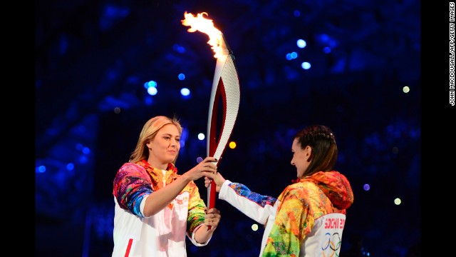 Russian tennis player and Olympic silver medalist Maria Sharapova, left, passes the Olympic torch to pole-vaulting legend Yelena Isinbayeva.