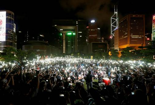 Pro-democracy protesters switch on their mobile phones in an act of defiance in China - but China is a socialist economy.