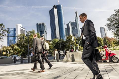 couple of business men wearing suits walk the streets of Frankfurt in Germany
