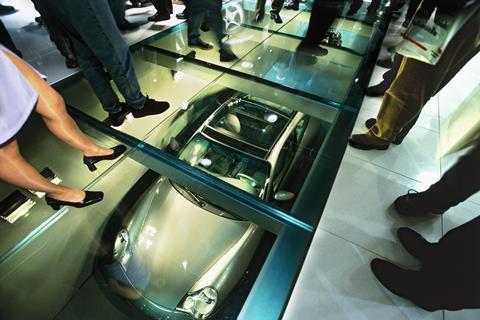 an aerial photo of a sports car is seeing thru glass inside a factory