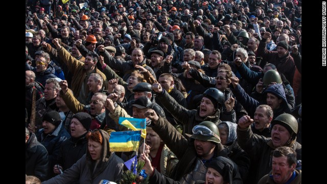 Protesters cheer after news of an agreement between the opposing sides in Kiev on February 21.