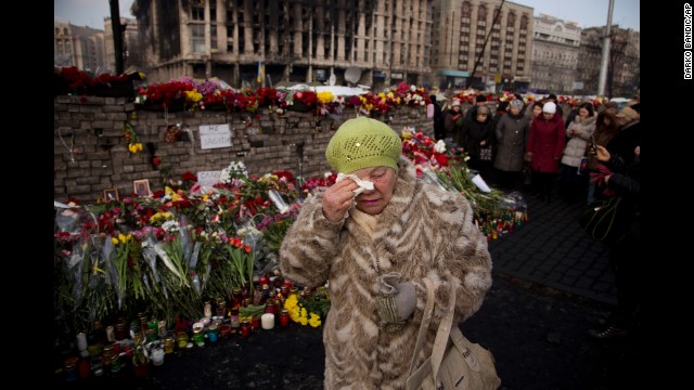 A woman cries February 24 near a memorial for the people killed in Kiev.