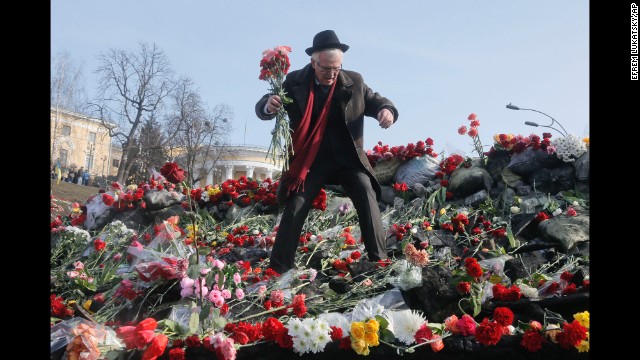 A man places flowers at a barricade near Independence Square on February 26.