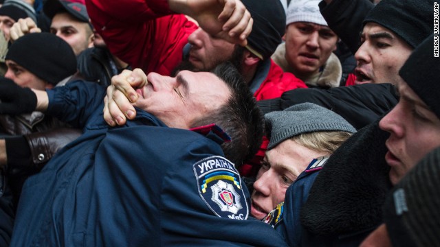A police officer gets pulled into a crowd of Crimean Tatars in Simferopol on February 26. The Tatars, an ethnic minority group deported during the Stalin era, is rallying in support of Ukraine's interim government.