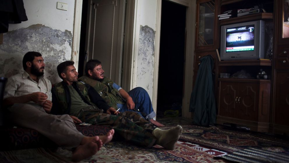 PHOTO: Syrian opposition fighters watch television