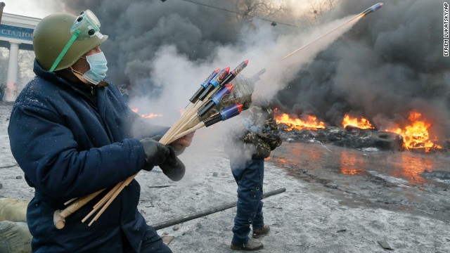 A protester shoots fireworks at police during clashes in Kiev on January 23.