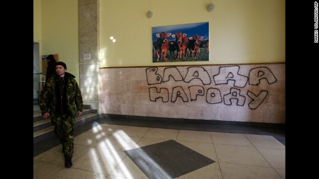 A protester passes past graffiti that reads Government for People in the Ministry of Agricultural Policy building in Kiev on January 24.